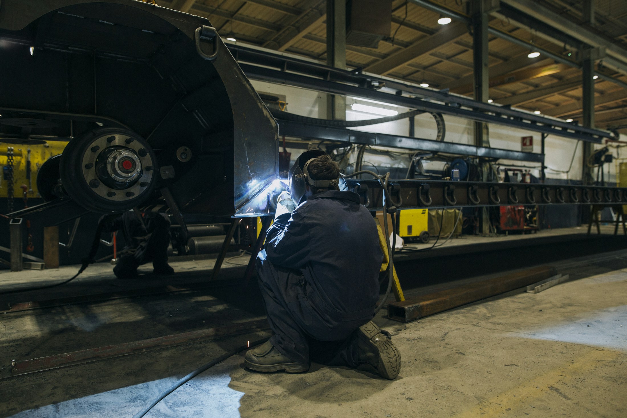 A welder working on an industrial assembly in Québec